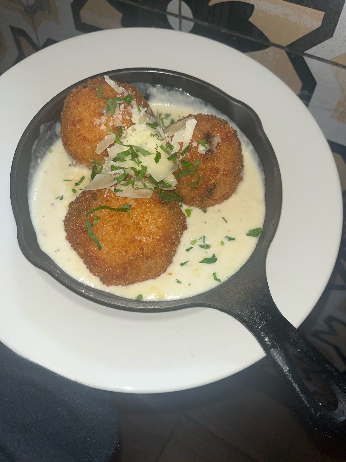 Rice balls in a skillet of cream sauce