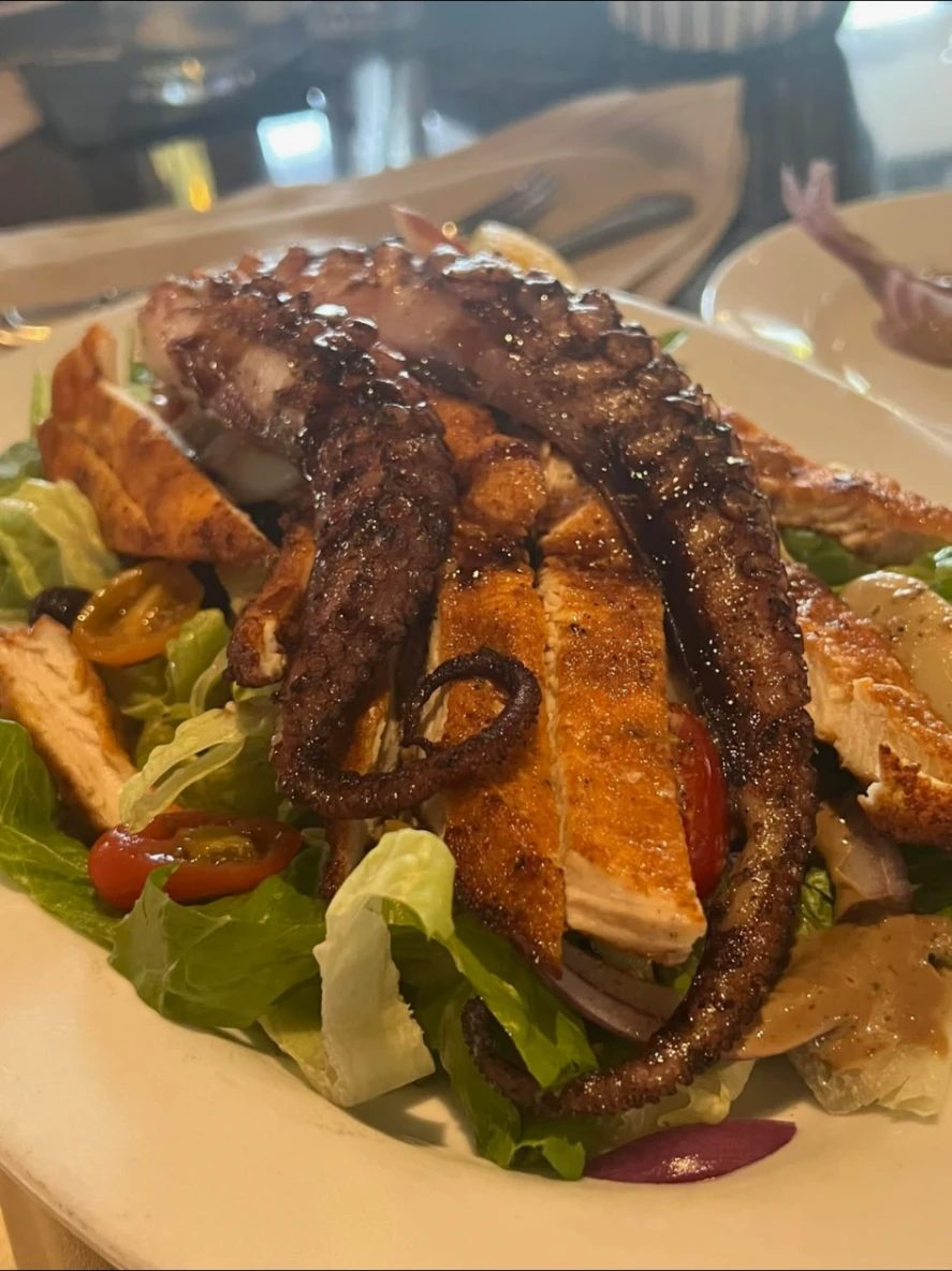 Grilled octopus over a fresh salad