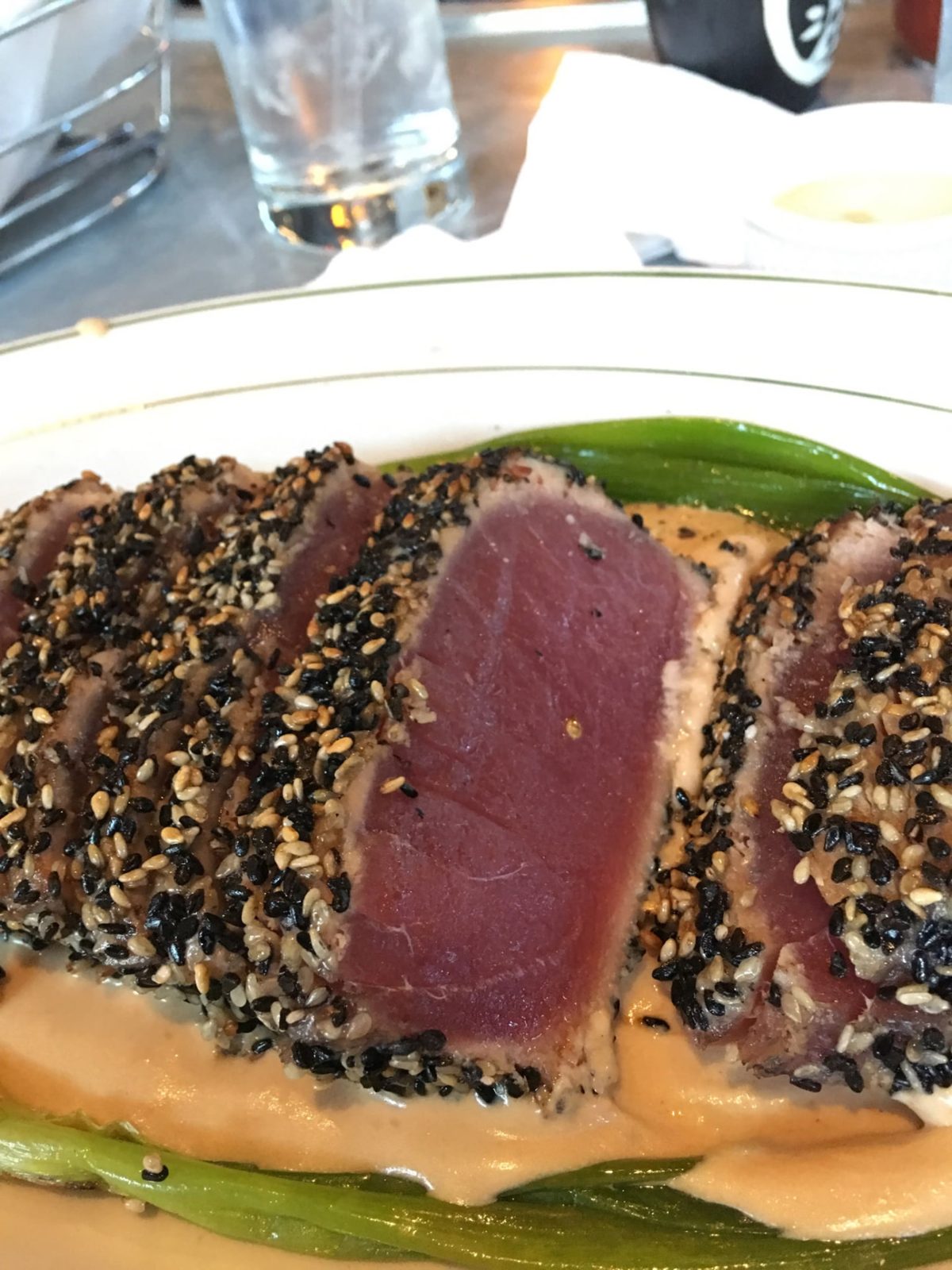 Seared sesame-crusted tuna over a creamy sauce